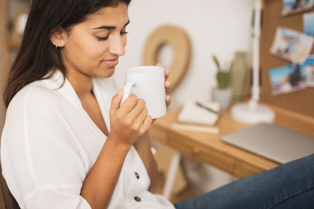 Schöne Frau, die eine Kaffeetasse anhält