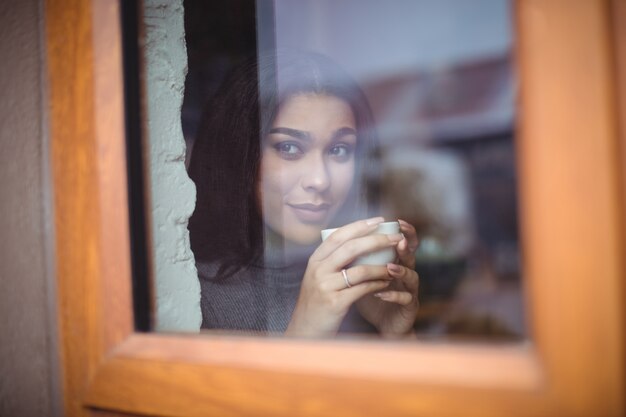 Schöne Frau, die eine Tasse Kaffee im Café hat