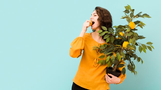 Schöne Frau, die einen Baum hält