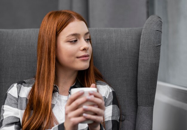 Schöne Frau, die einen Becher anhält