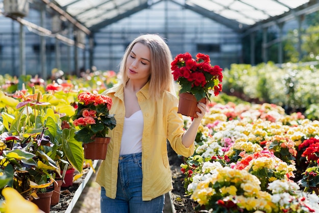 Schöne Frau, die heraus nach Blumen sucht