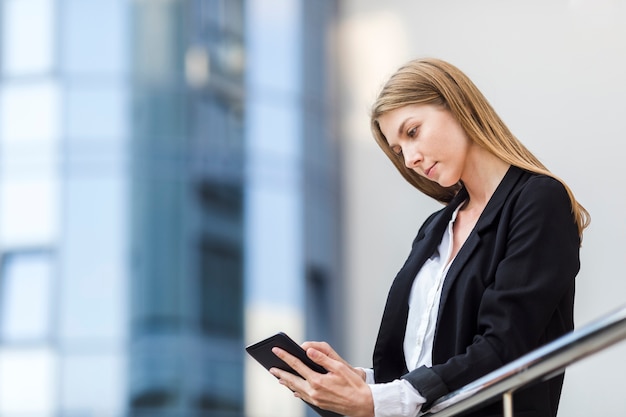 Schöne Frau, die ihre Tablette überprüft