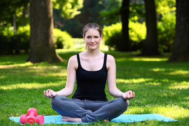 Schöne Frau, die in Yoga-Haltung entspannt