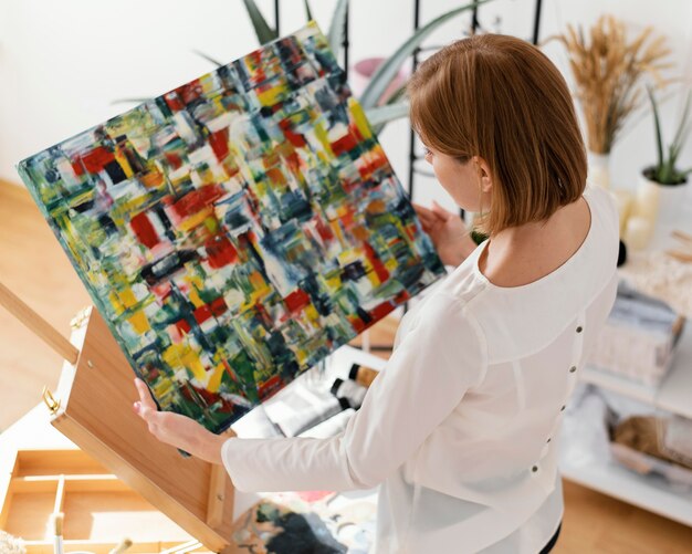 Schöne Frau, die mit Acryl auf Leinwand malt
