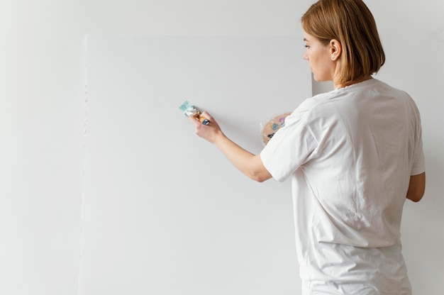 Schöne Frau, die mit Acryl auf Leinwand malt