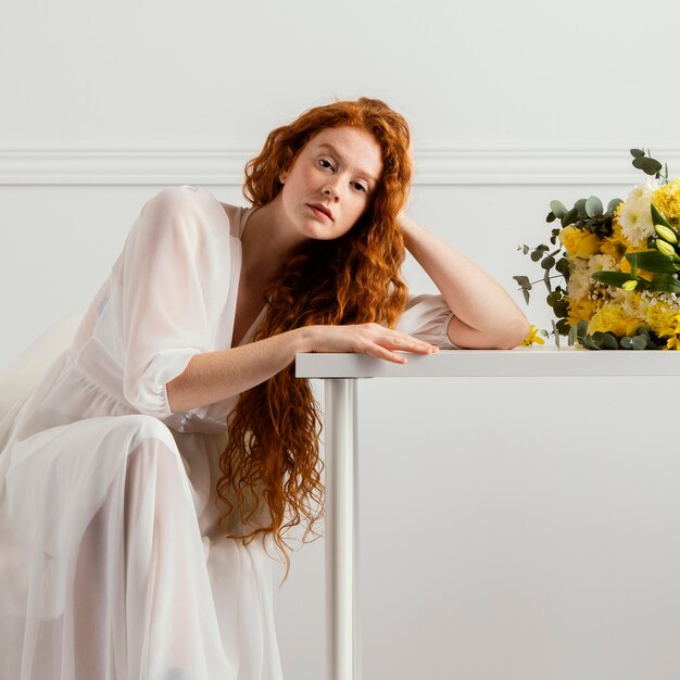 Schöne Frau, die mit Blumenstrauß der Frühlingsblumen aufwirft