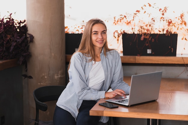 Schöne Frau, die mit einem Laptop sitzt