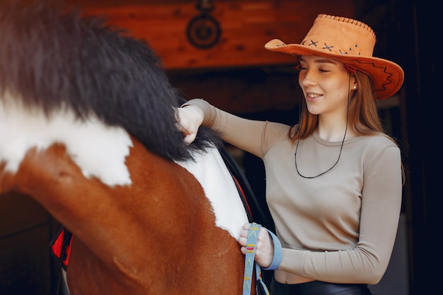 Schöne Frau, die mit einem Pferd steht