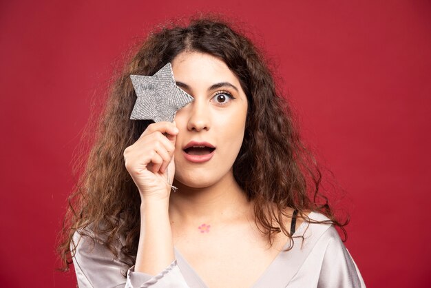 Schöne Frau, die mit glitzerndem Stern aufwirft.