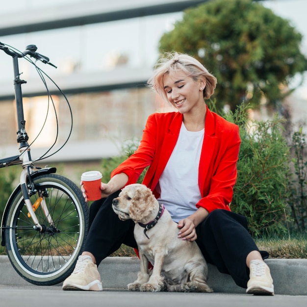 Schöne Frau, die mit ihrem Hund spielt