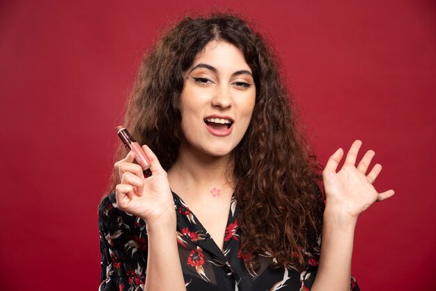 Schöne Frau, die nackten Lippenstift hält.