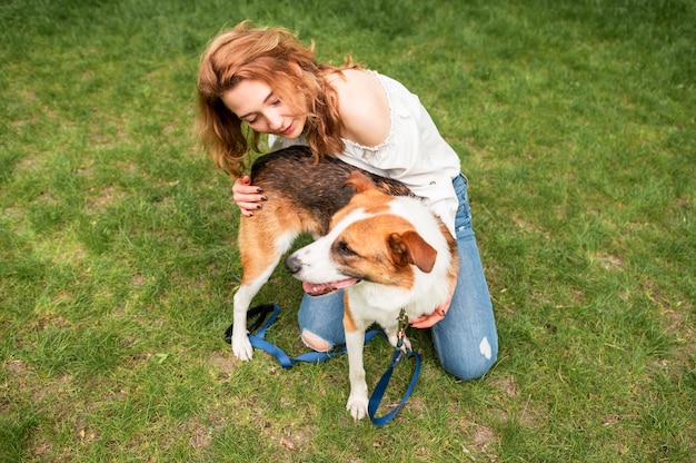 Schöne Frau, die Natur mit ihrem Hund genießt