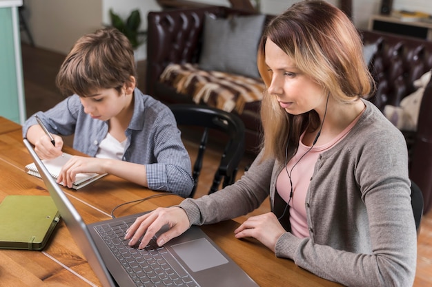 Schöne Frau, die neben dem Jungen arbeitet