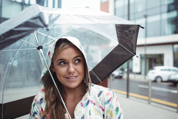 Schöne frau, die regenschirm hält