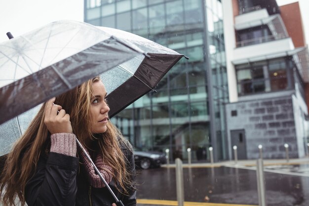 Schöne Frau, die Regenschirm hält