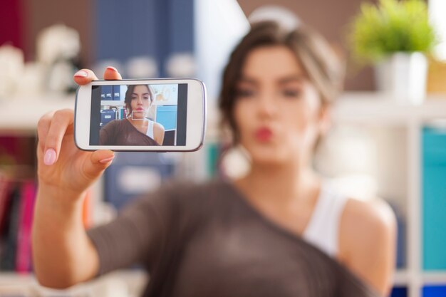 Schöne Frau, die selfie Foto mit einem Kuss bläst