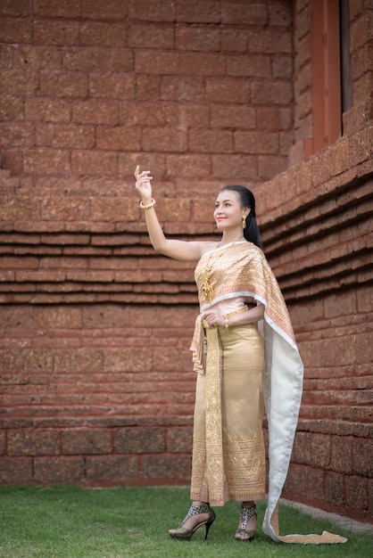 Schöne Frau, die typisches thailändisches Kleid trägt