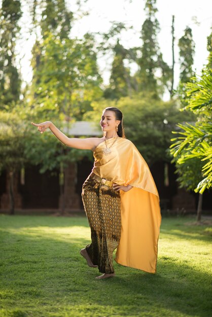 Schöne Frau, die typisches thailändisches Kleid trägt