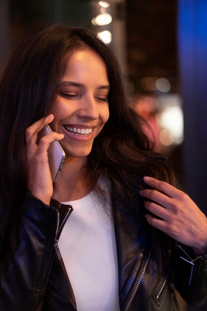 Schöne Frau, die während einer Nacht am Telefon telefoniert