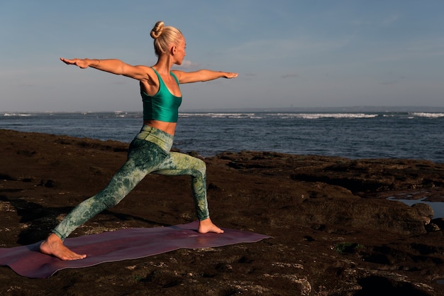 Kostenloses Foto schöne frau, die yoga tut. mittlerer plan