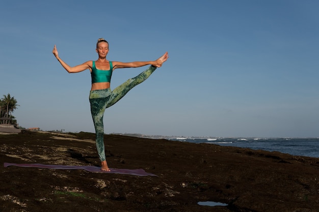 Schöne Frau, die Yoga tut. mittlerer Plan