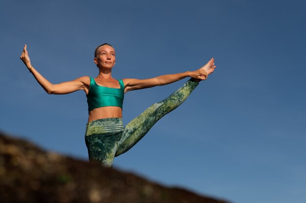 Schöne Frau, die Yoga tut. mittlerer Plan