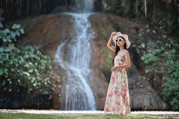 Schöne Frau im Kleid am Wasserfall