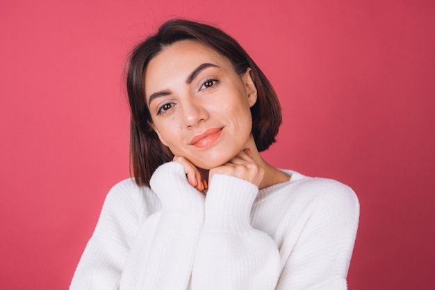 Schöne Frau im lässigen weißen Pullover, isoliertes stehendes ruhiges Gesicht niedliches Lächeln kopieren Raum