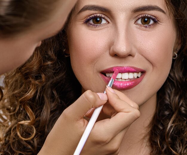 Schöne Frau im Schönheitssalon, die Make-up tut