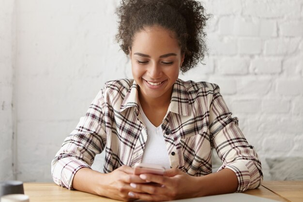 Schöne Frau in einem Café auf ihrem Smartphone