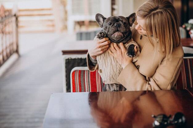 Schöne Frau mit ihrer netten französischen Bulldogge in der warmen Ausstattung