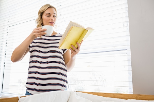 Schöne Frau mit Kaffeetasse und Lesebuch