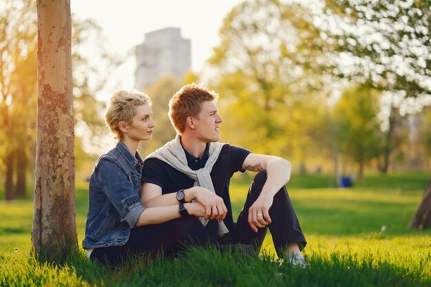 schöne Frau mit kurzen hellen Haaren, gekleidet in einer Blue Jeans Jacke sitzt mit ihrem Freund