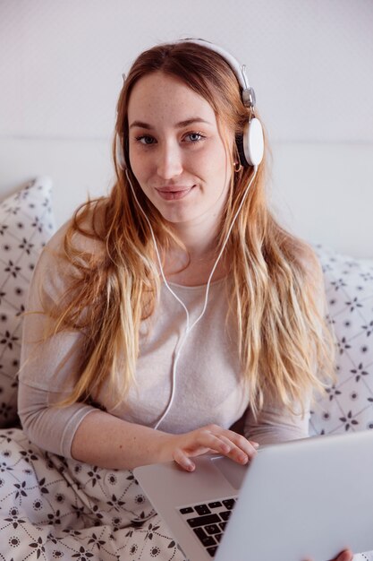 Schöne Frau mit Laptop und Kopfhörer