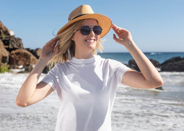 Schöne Frau mit Panamahut, die am Strand chillt