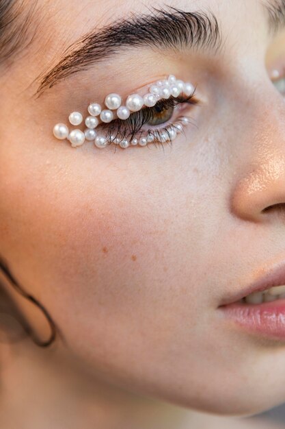 Schöne Frau mit Perlen schminken