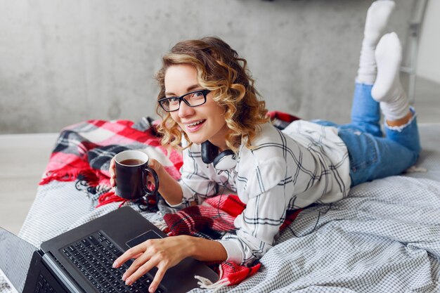 Schöne Frau mit Tasse Kaffee und Laptop