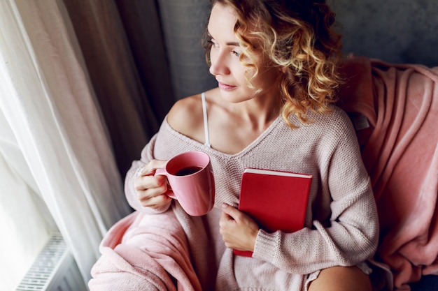 Schöne Frau mit Tasse Kaffee und Lesen