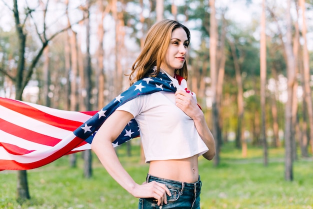 Kostenloses Foto schöne frau mit usa-flagge um stutzen