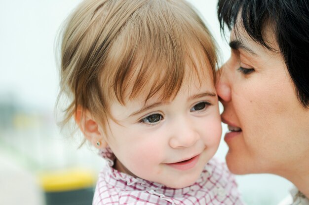 Schöne Frau und ihre süße kleine Tochter umarmen