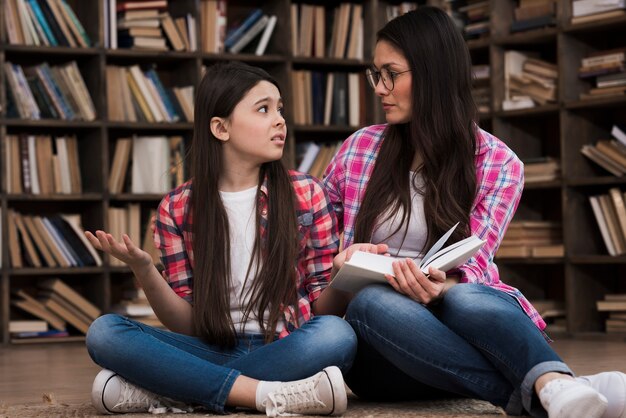 Schöne Frau und junges Mädchen in der Bibliothek