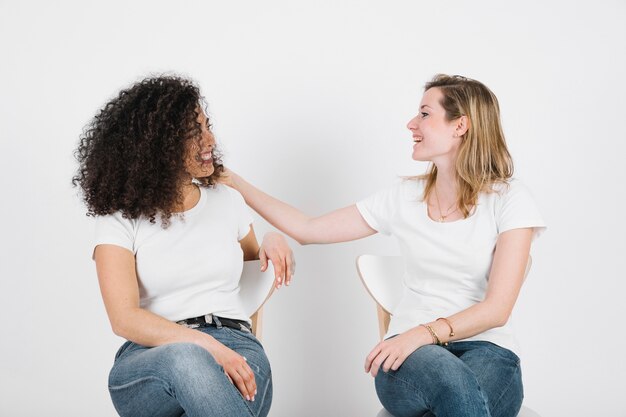 Schöne Frauen, die auf Stühlen kommunizieren