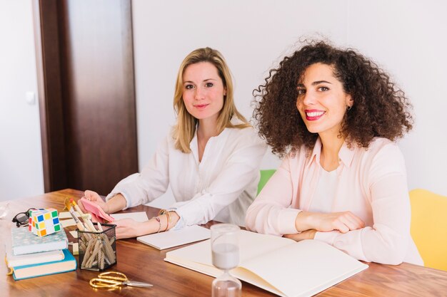 Schöne Frauen, die bei Tisch studieren