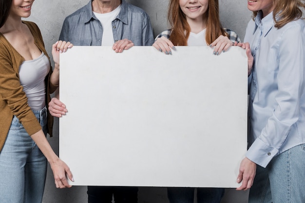 Schöne Frauen, die ein Zeichen zusammenhalten