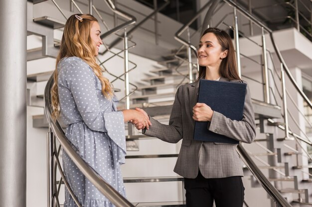 Schöne Frauen, die Hände rütteln