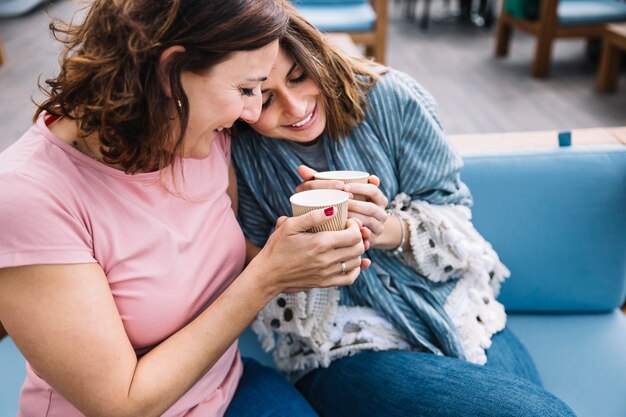 Schöne Frauen, die heißes Getränk trinken