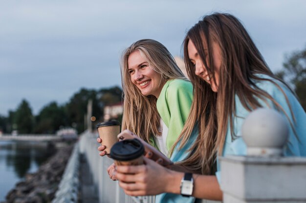 Schöne Frauen, die Kaffeetassen anhalten