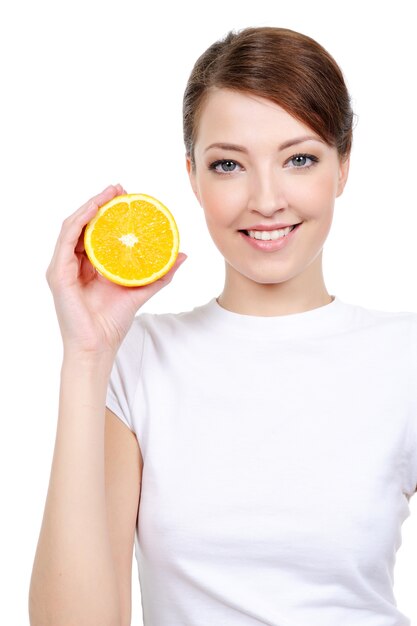 Schöne fröhliche Frau mit frischem Orange nahe ihrem Gesicht