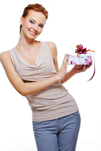 Schöne fröhliche junge Frau, die die kleine Geschenkbox hält