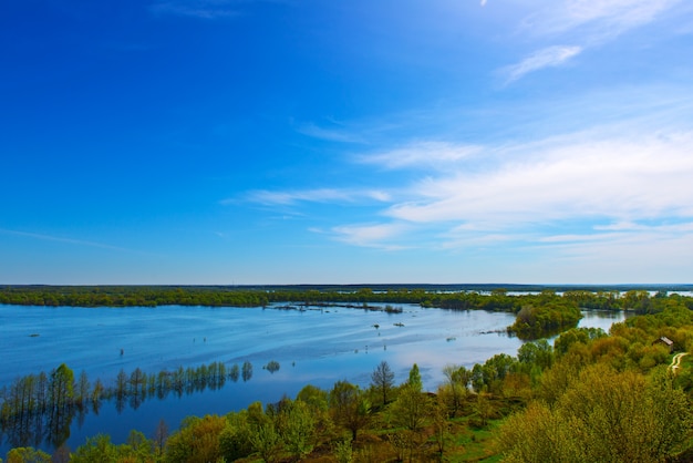 Schöne Frühlingslandschaft. Erstaunliche Aussicht auf die Fluten vom Hügel. Europa. Ukraine. Beeindruckender blauer Himmel mit weißen Wolken. Ukraine. Europa